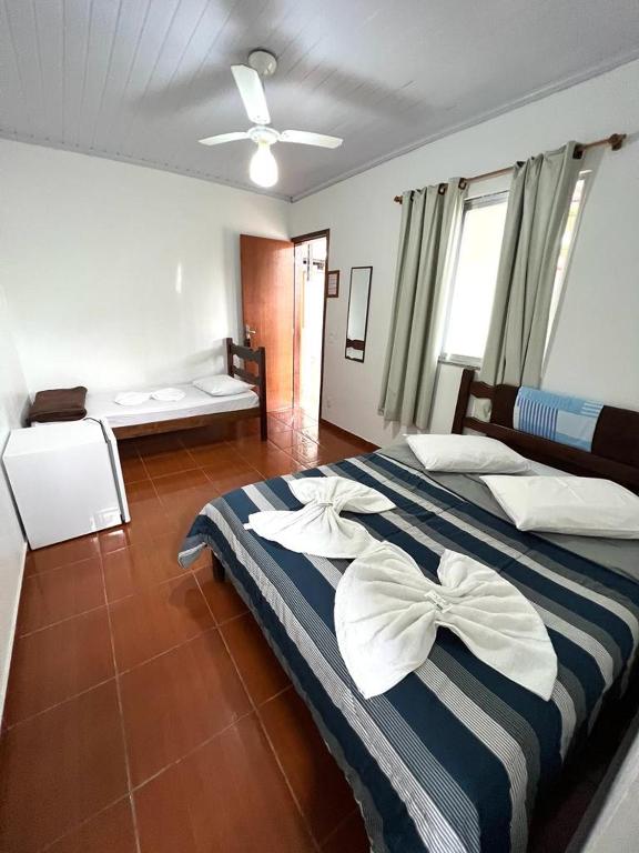 a bedroom with a large bed with white and blue stripes at Pousada do Genesio in Petrópolis