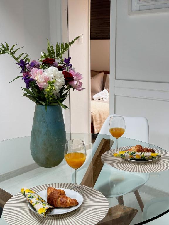 einen Tisch mit zwei Teller Essen und eine Vase mit Blumen in der Unterkunft Mira's Apartment in Križevci