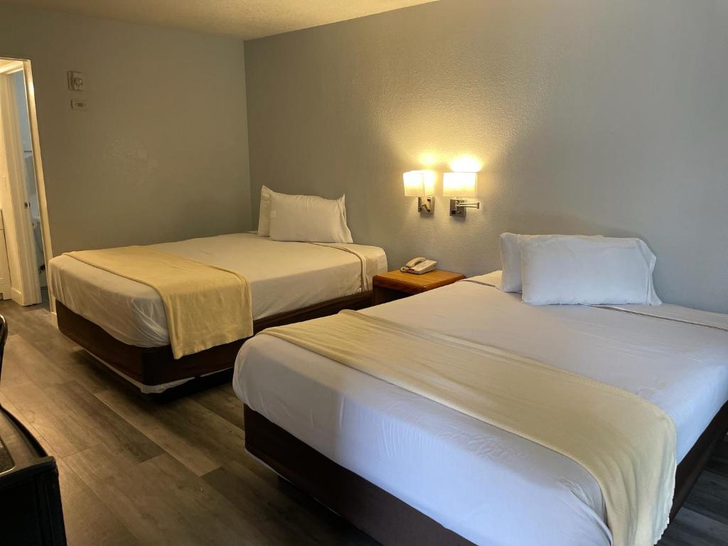 una camera d'albergo con due letti e un telefono appeso al muro di Premier Inns Thousand Oaks a Thousand Oaks
