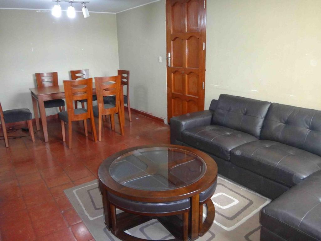 een woonkamer met een bank en een tafel en stoelen bij Vane House in Lima