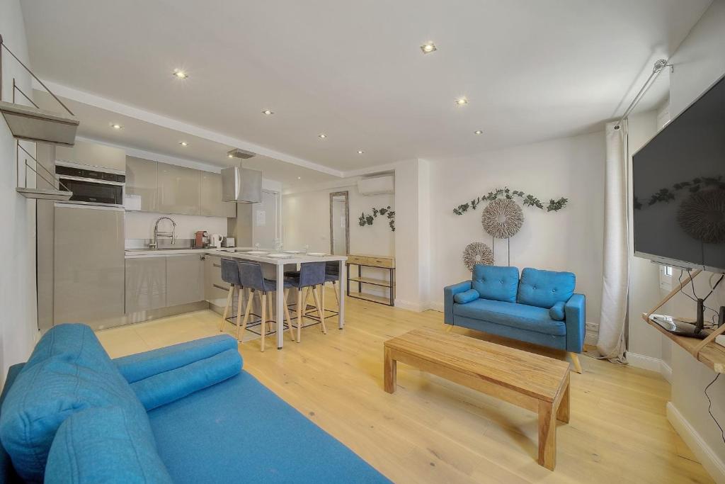 un salon avec un canapé bleu et une cuisine dans l'établissement IMMOGROOM - Heart of the Suquet - City center - Modern, à Cannes