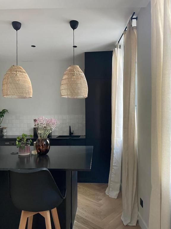 eine Küche mit einer schwarzen Theke und zwei Hängelampen in der Unterkunft Appartement plein de charme au cœur du Vieux-Lyon in Lyon