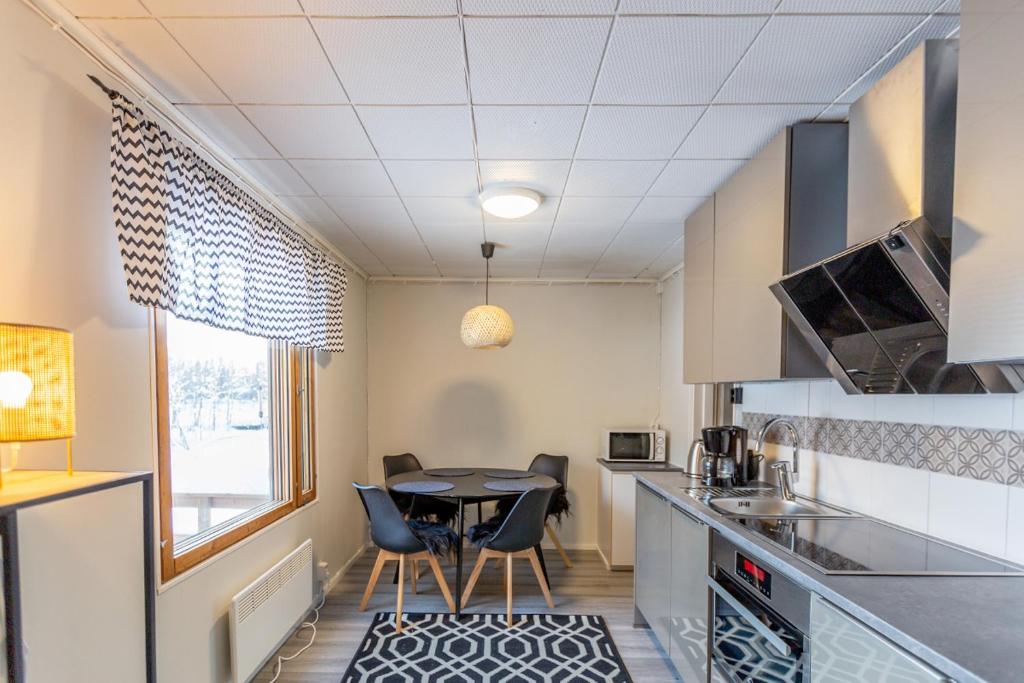 - une cuisine avec une table et des chaises dans la chambre dans l'établissement Kuukkeli Ivalo Arctic House, à Ivalo