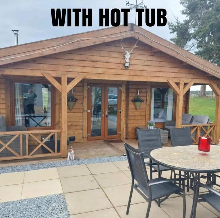 a cabin with a deck with a table at Hillhaven Lodge in Inverness