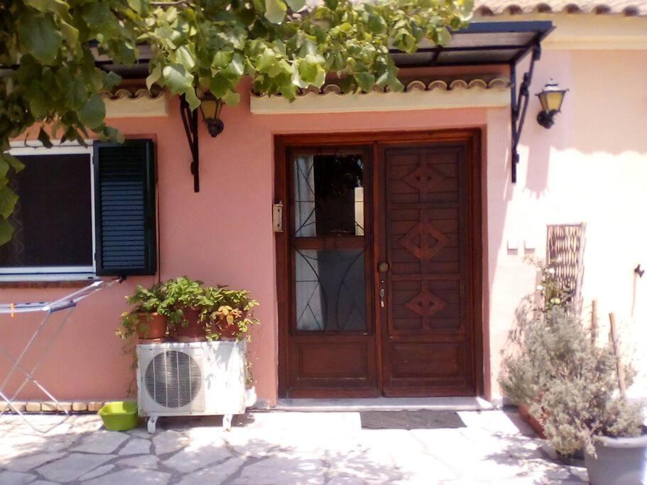 a house with a wooden door with flowers in front at 56s.m comftorable studio,airport area in Anemómylos
