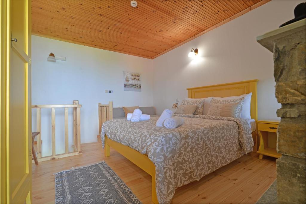 een slaapkamer met een bed met kussens erop bij To Patriko Mas Guesthouse-1 in Palaios Panteleimon