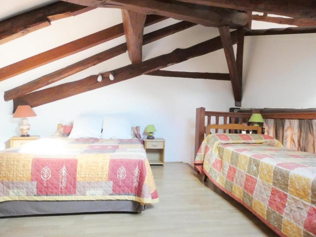 two beds in a room with wooden ceilings at Aurus ii in Saint-Paul-lès-Dax