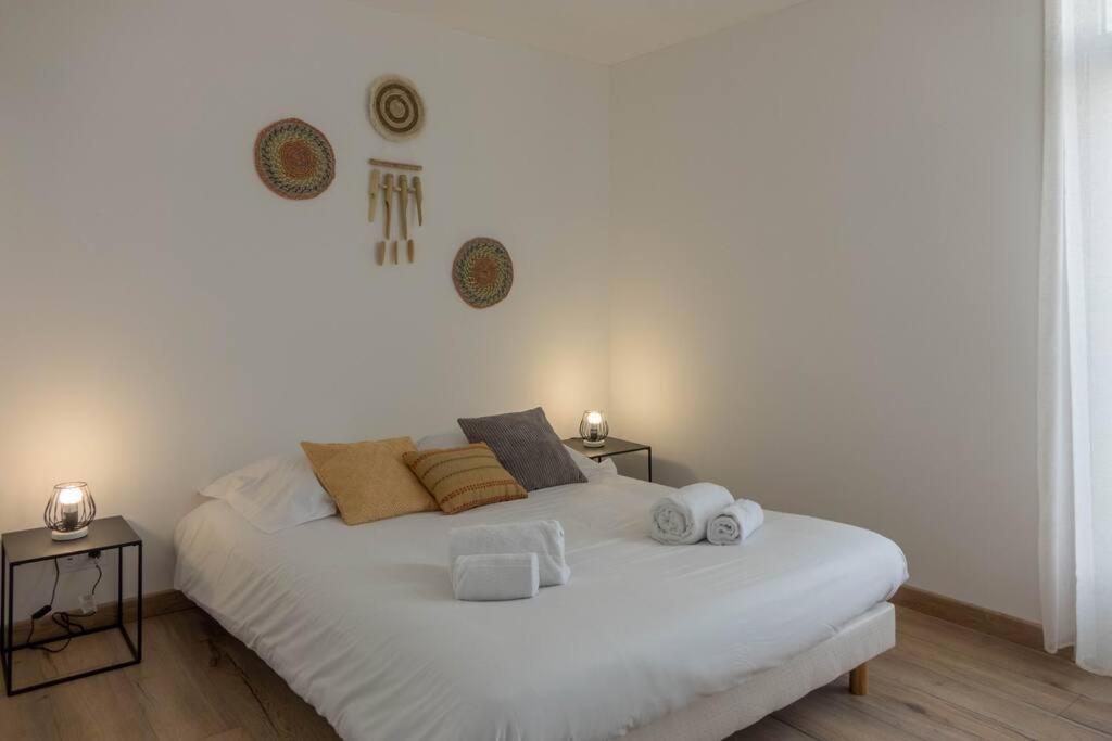a bedroom with a large white bed with two tables at Le Gambetta *T3* + Parking in Saint-Jean-de-la-Ruelle