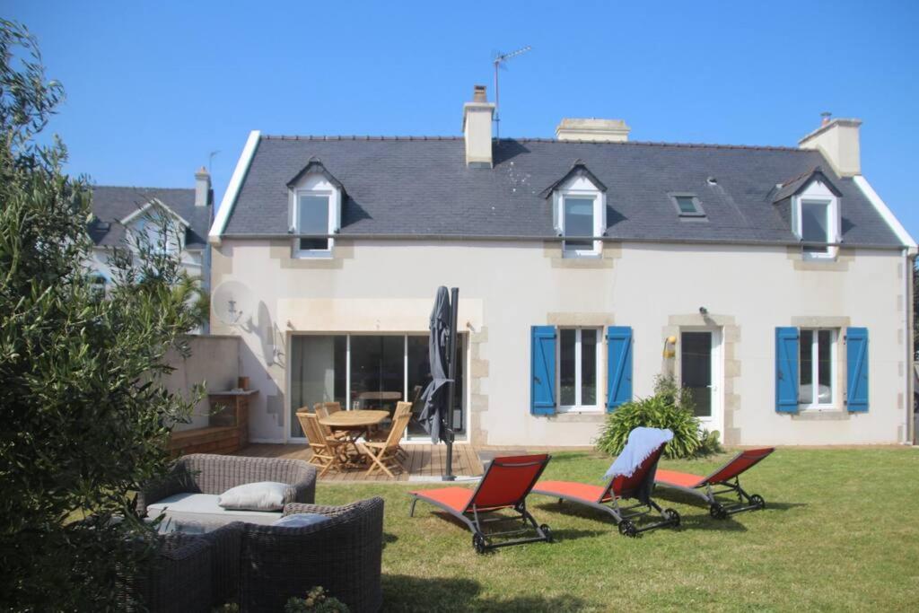 une maison avec des chaises et une table dans la cour dans l'établissement « La maison de vacances » à 50 mètres de la plage, à Sibiril