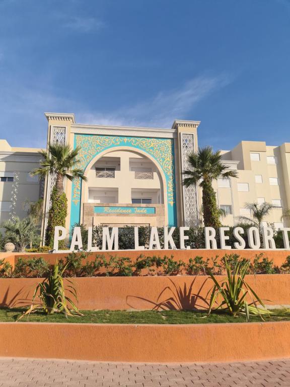 莫納斯提爾的住宿－Palm Lake Resort Folla Monastir vue Piscine，看棕榈树在建筑前的标志