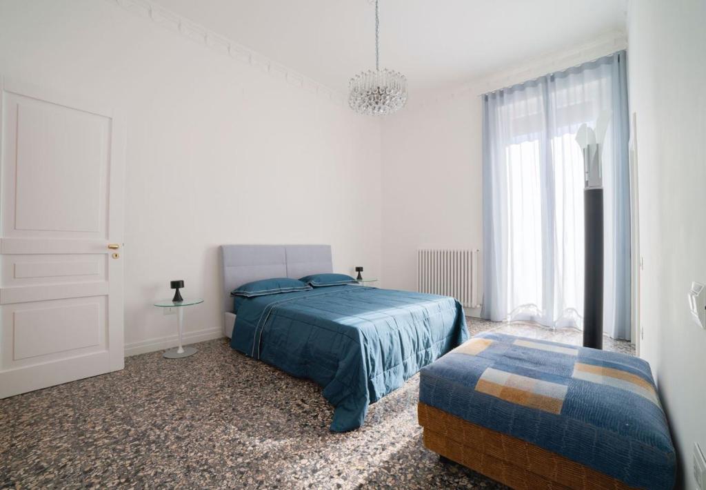 a white bedroom with a bed and a window at AM Apartment in Cosenza
