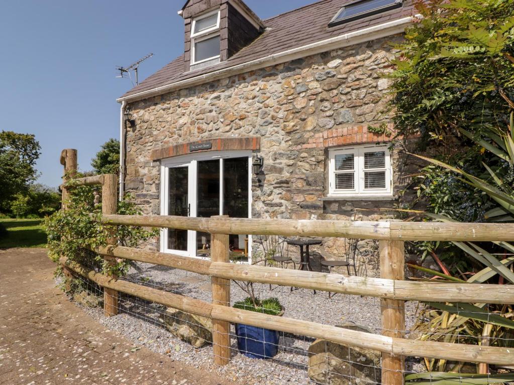 a stone house with a wooden fence in front of it at The Coach House in Haverfordwest