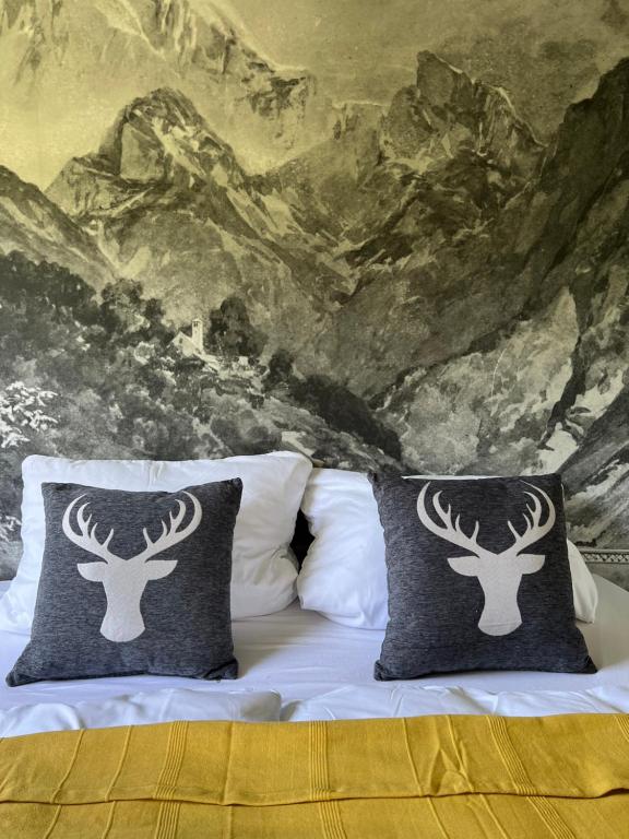 a bed with two pillows with a painting of deer heads at Bavaria Mountain Lodge SKI Arber Osser Bayrischer Wald DESIGNER Ferienwohnung in Lohberg