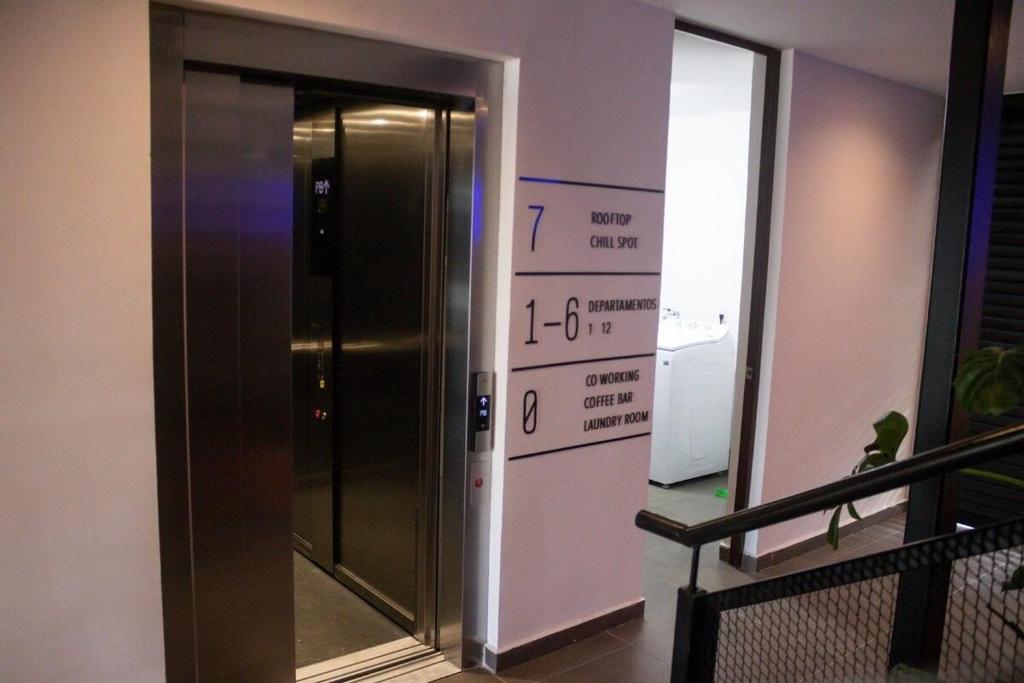 an elevator in a building with a sign on the wall at Moderno y Comodo Loft Asoluta in Mérida