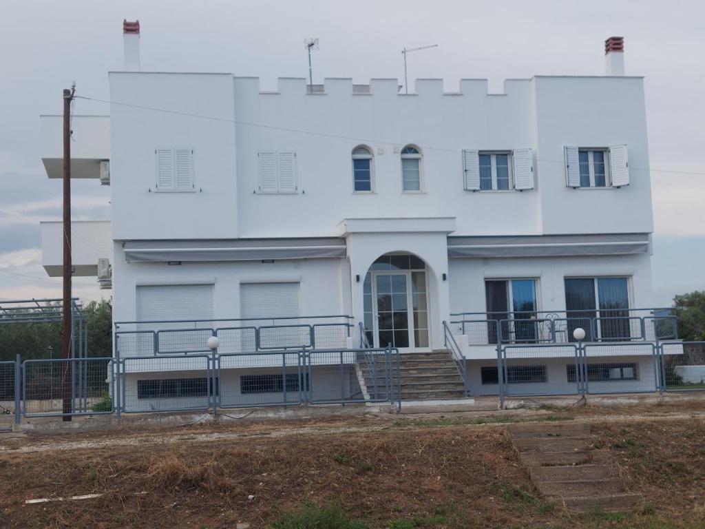 un edificio blanco con una escalera delante en Kastro Apartments, en Kalivia Poligirou