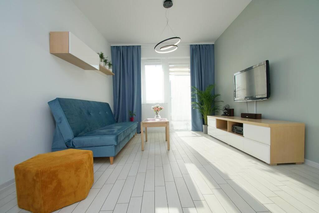 un soggiorno con divano blu e TV di Apartament, Chorzowska 216 a Katowice