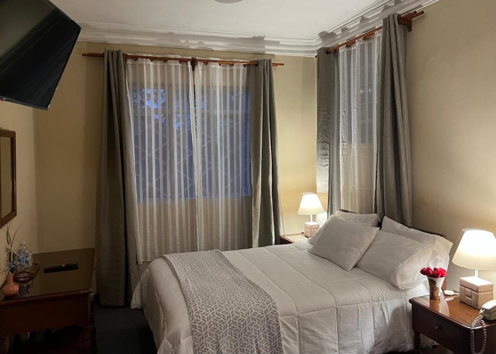 a bedroom with a bed and a large window at El Balcon Hostal Turistico in Arequipa