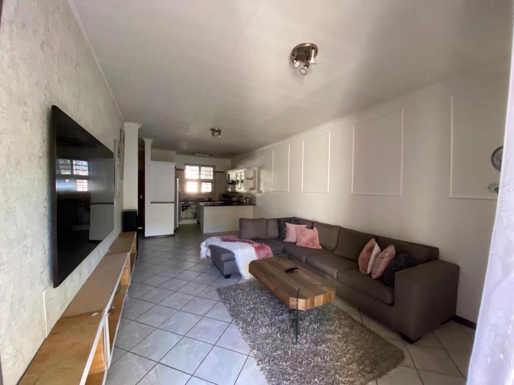 a living room with a couch and a tv at Siena Sun Apartment 4 in Midrand