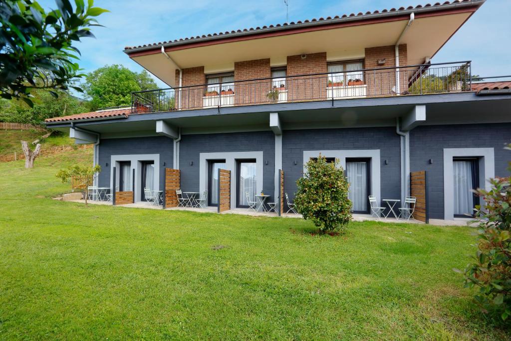 a house with a lawn in front of it at Mendi Azpi Rooms in Mutriku