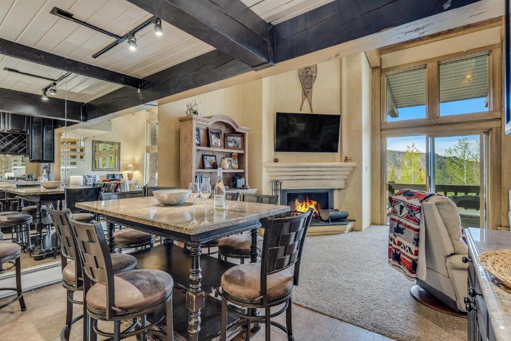 a kitchen with a large table and chairs and a fireplace at Interlude Condominiums 3-Bedroom Unit 302 in Snowmass Village