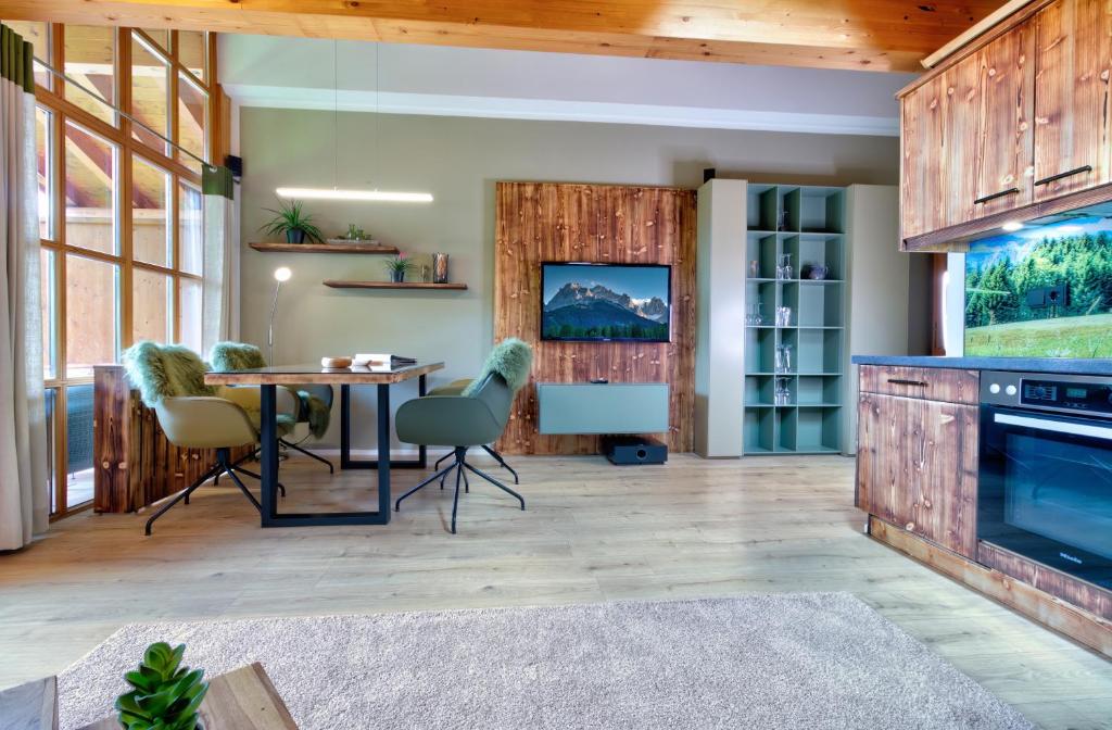 a dining room with a table and chairs and wooden walls at Gipfelglück in Reit im Winkl