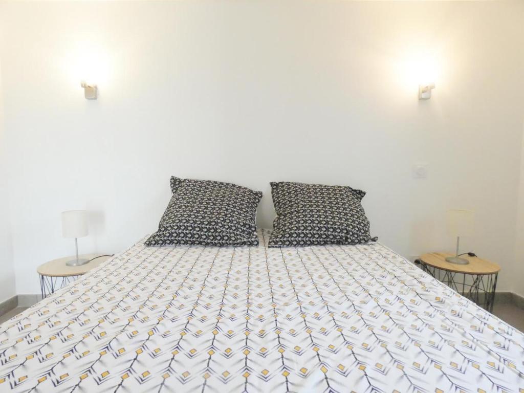 a white bed with two pillows in a bedroom at Pierron in Linxe