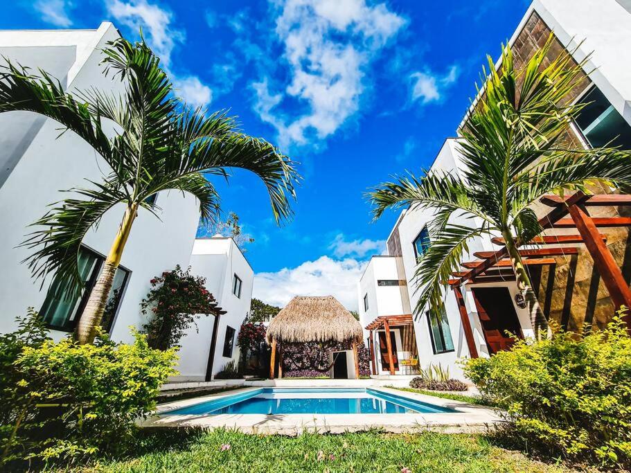 uma villa com piscina e palmeiras em Casa Mágico Bacalar em Bacalar