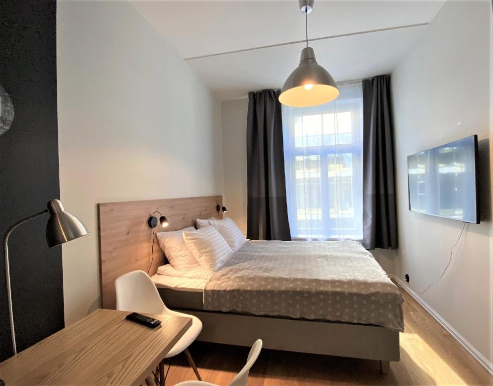 タリンにあるRotermann Central Apartmentsのベッドと机と窓のある寝室