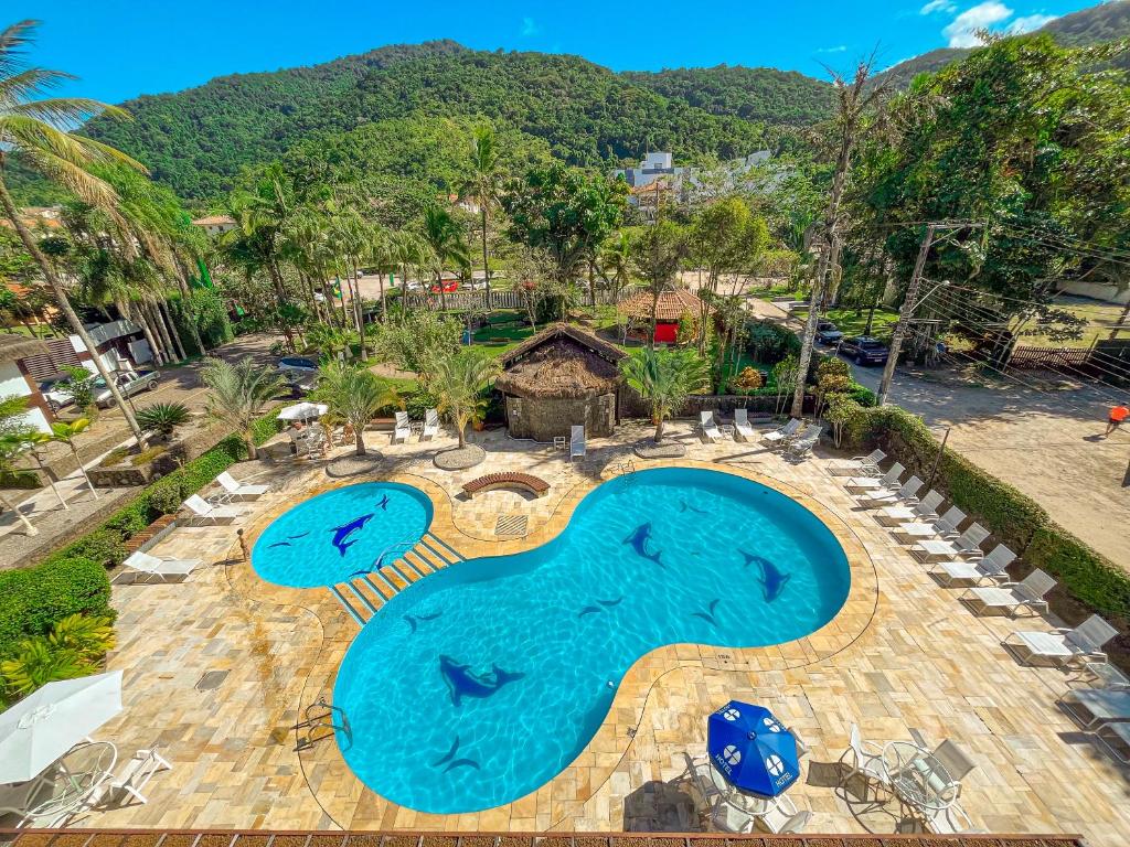 an overhead view of a swimming pool with blue water at Hotel Nacional Inn Ubatuba - Praia das Toninhas in Ubatuba