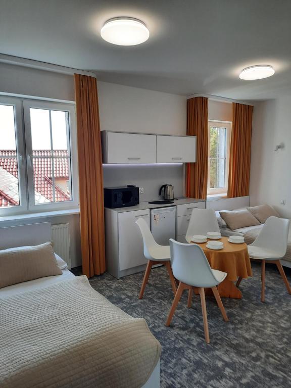 pokój hotelowy z łóżkiem, stołem i krzesłami w obiekcie Dom Wczasowy KORMORAN Niechorze - 300m od plaży w mieście Niechorze