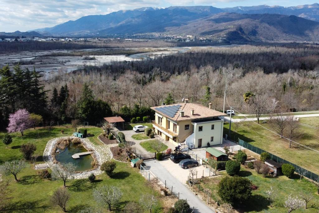 - une vue aérienne sur une maison avec une rivière et des montagnes dans l'établissement Parkland site, à Valdobbiadene