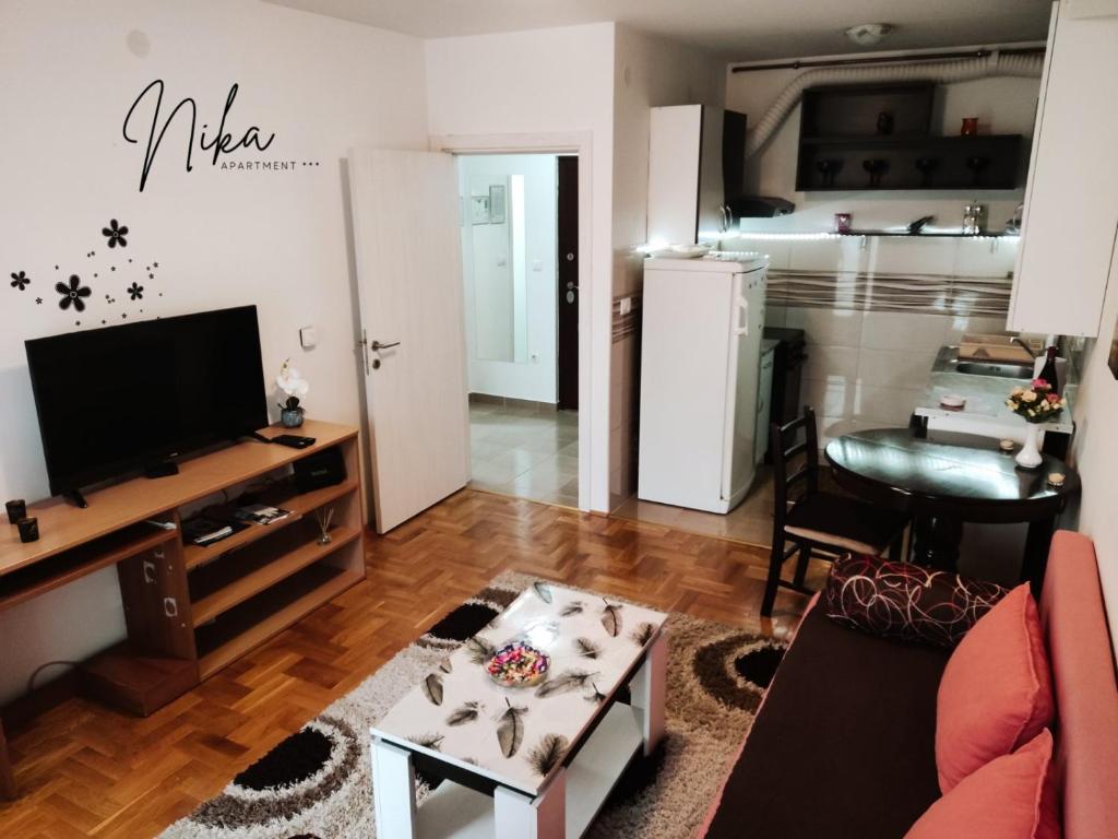 ein Wohnzimmer mit einem Sofa und einem Tisch in der Unterkunft Apartman Nika in Kragujevac