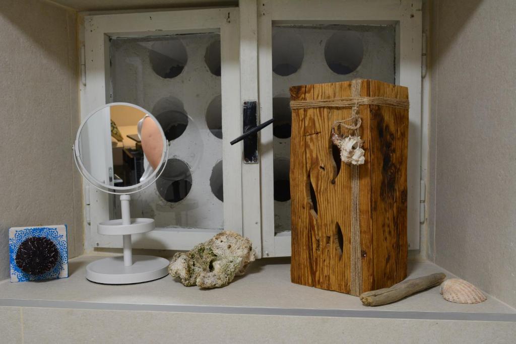 ein Regal mit einem Spiegel und anderen Gegenständen darauf in der Unterkunft VILLA MOST Tisno in Tisno