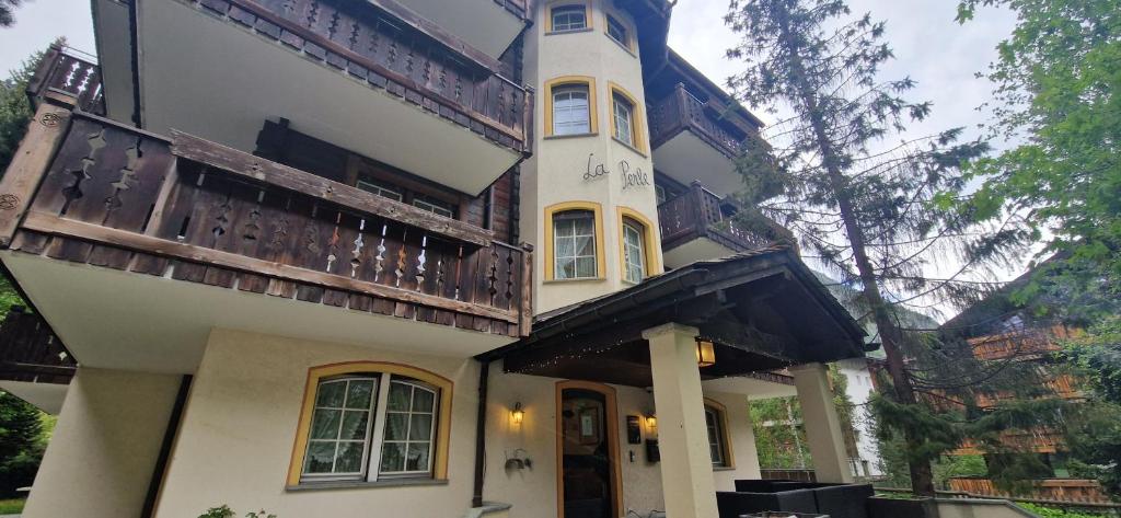 a large white building with a balcony on it at La Perle Apartments in Zermatt