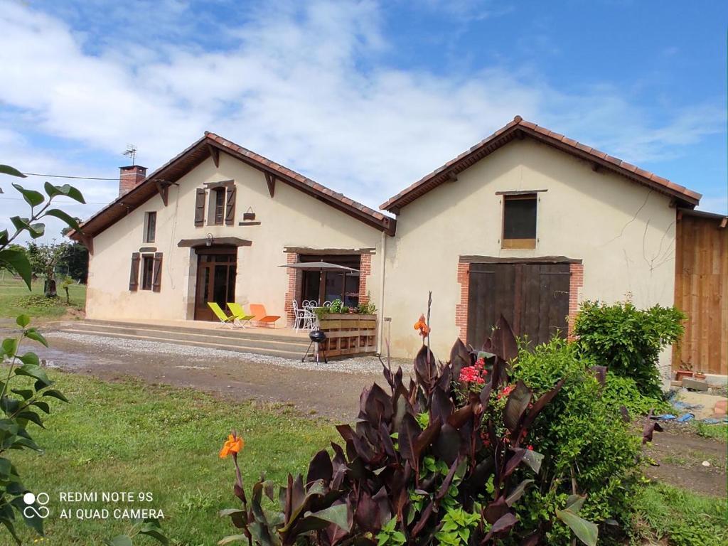 ein kleines weißes Haus mit Garage davor in der Unterkunft Le petit saou du becq in Saint-Lon-les-Mines