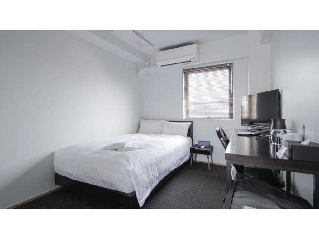 a white bedroom with a bed and a desk at 8HOTEL CHIGASAKI - Vacation STAY 87519v in Chigasaki