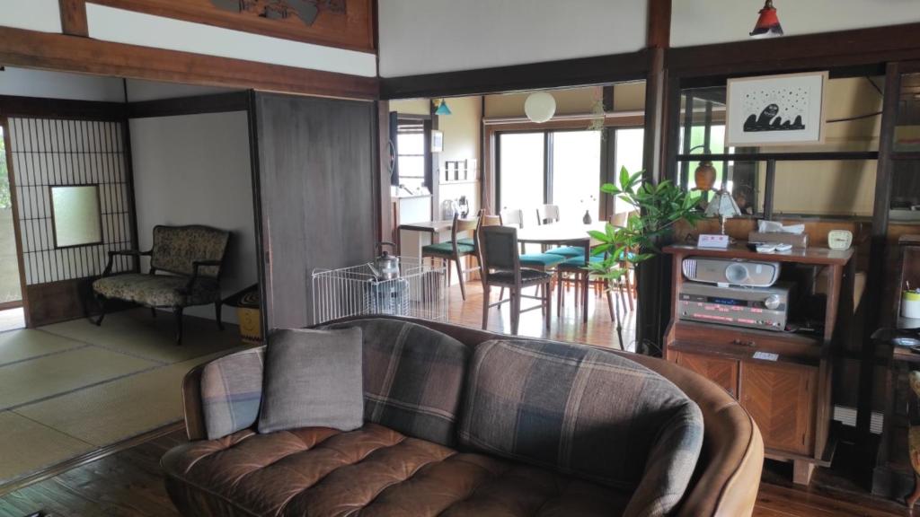 Higashiyama no Kobesso - Vacation STAY 14451 في كيتاكيوشو: غرفة معيشة مع أريكة وغرفة طعام