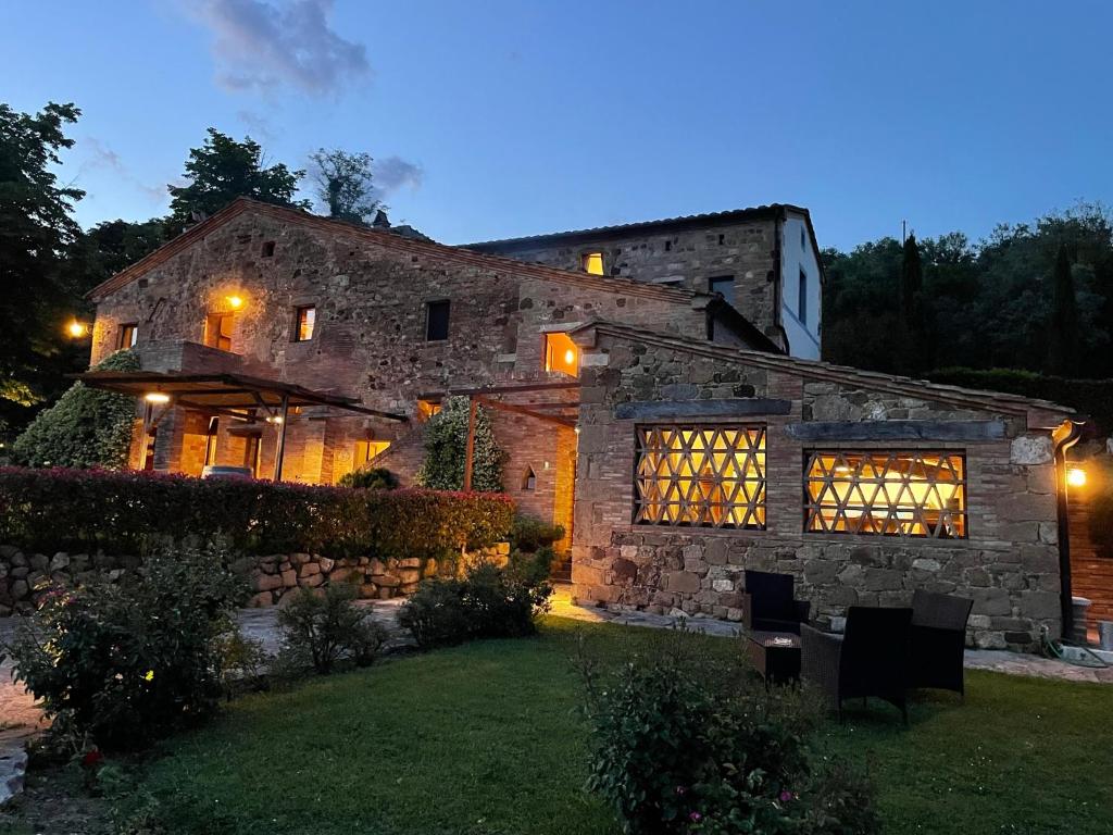 a large stone house with a yard at night at Godiolo in Montepulciano