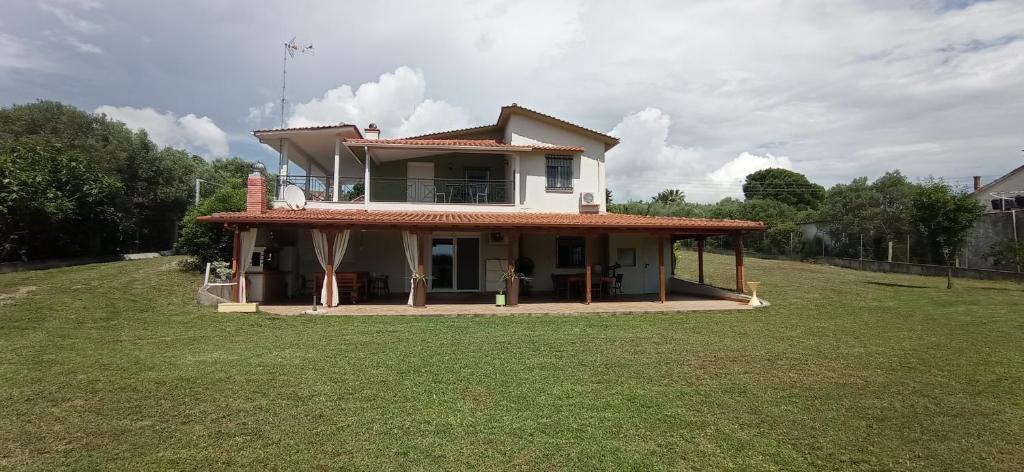 a house sitting on top of a lush green field at Casa Soare in Nea Kalikratia