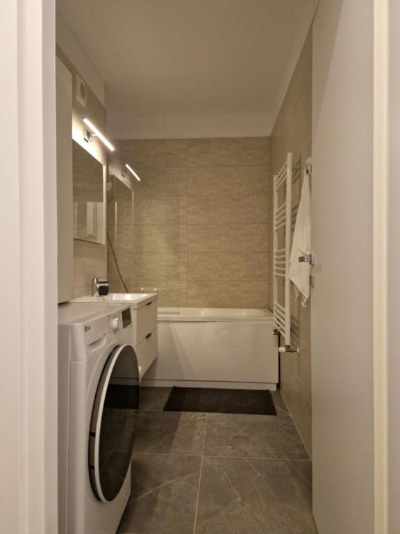 ein Badezimmer mit einem Waschbecken und einer Waschmaschine in der Unterkunft Onix View 37, Premium Parking in Bukarest