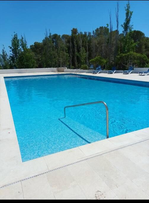 a large blue swimming pool with a metal rail at La calma de Tossa in Girona