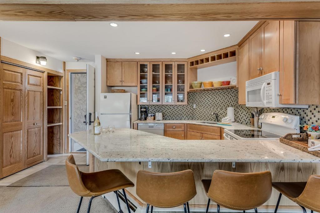 una cocina con armarios de madera y una encimera grande en Laurelwood Condominiums 105, en Snowmass Village