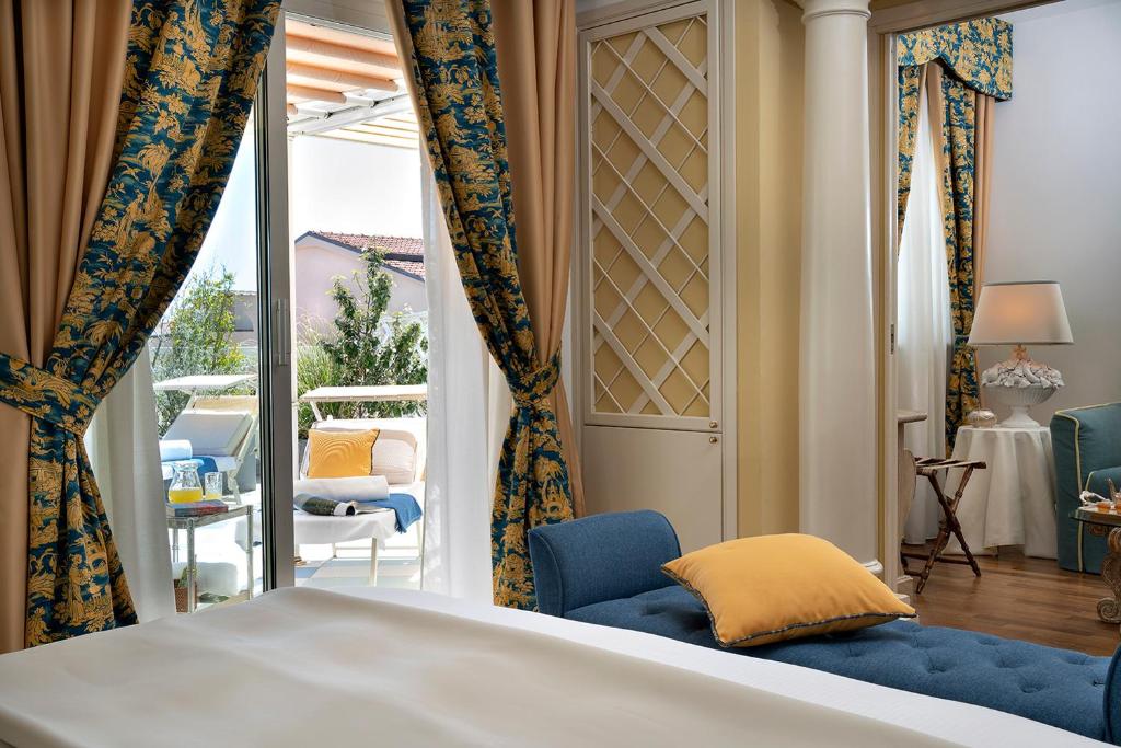 a bedroom with a bed and a view of a patio at Palace Hotel in Viareggio