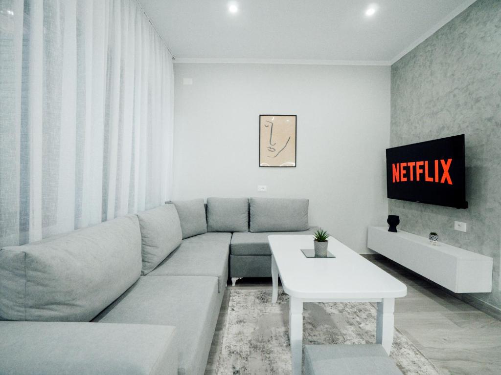 un soggiorno con un divano e una TV di Dionis House a Shkodër