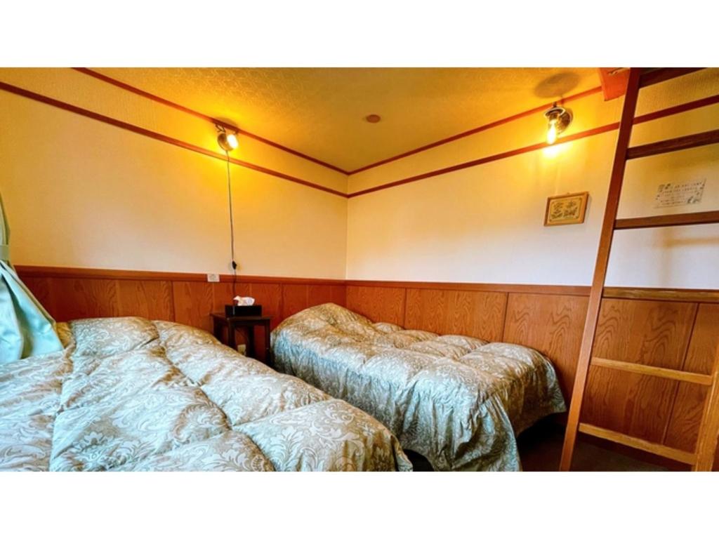 una camera con due letti e due scaffali di Hakuba Pension Meteor - Vacation STAY 63315v a Hakuba