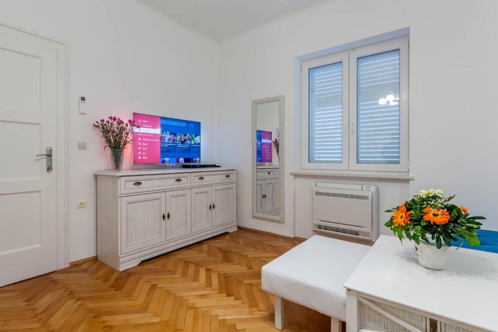 a kitchen with white cabinets and a table with flowers on it at Chic Apartment in Center in Split