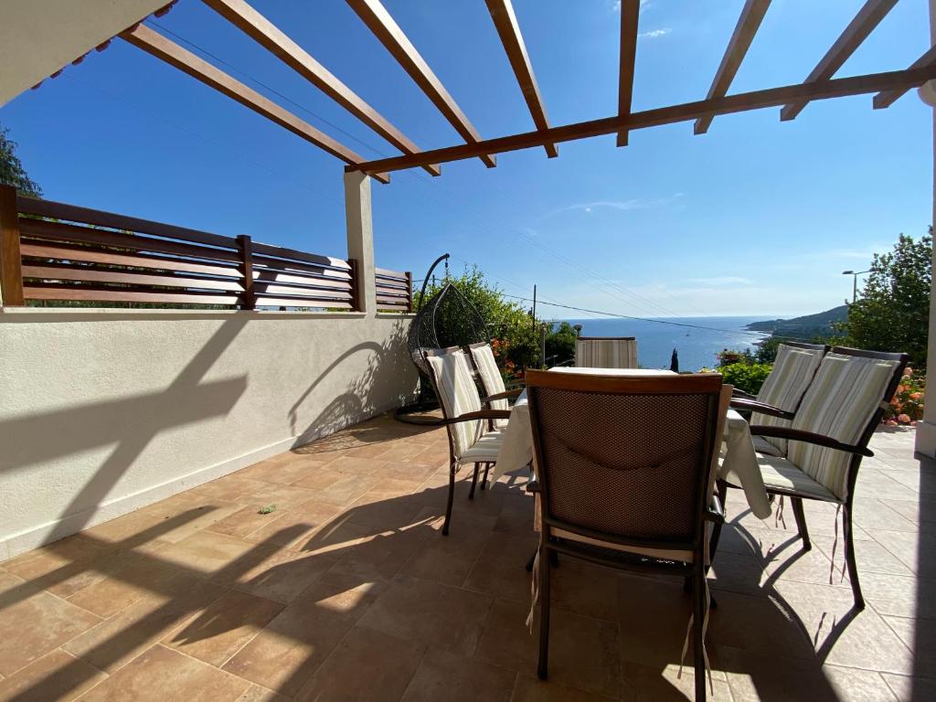 um pátio com cadeiras e uma mesa com vista para o oceano em Villa Pergola -Apartment Roko em Mlini