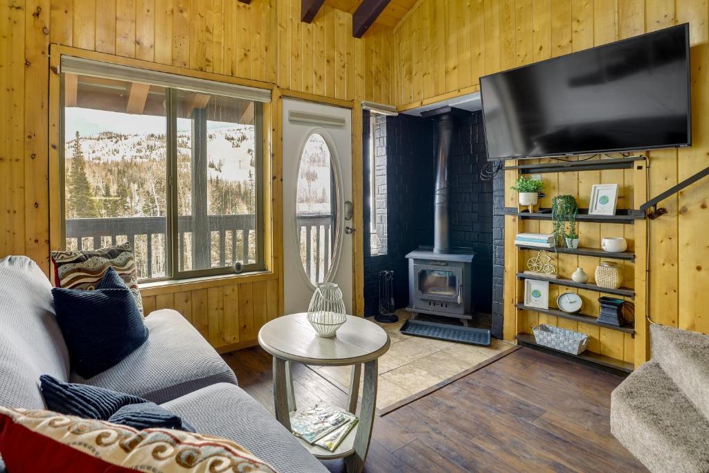 a living room with a couch and a stove at Brian Head Condo Walk to Giant Steps Ski Lifts! in Brian Head