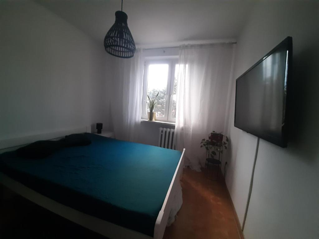 a bedroom with a bed and a flat screen tv at Mieszkanie Żywiec in Żywiec