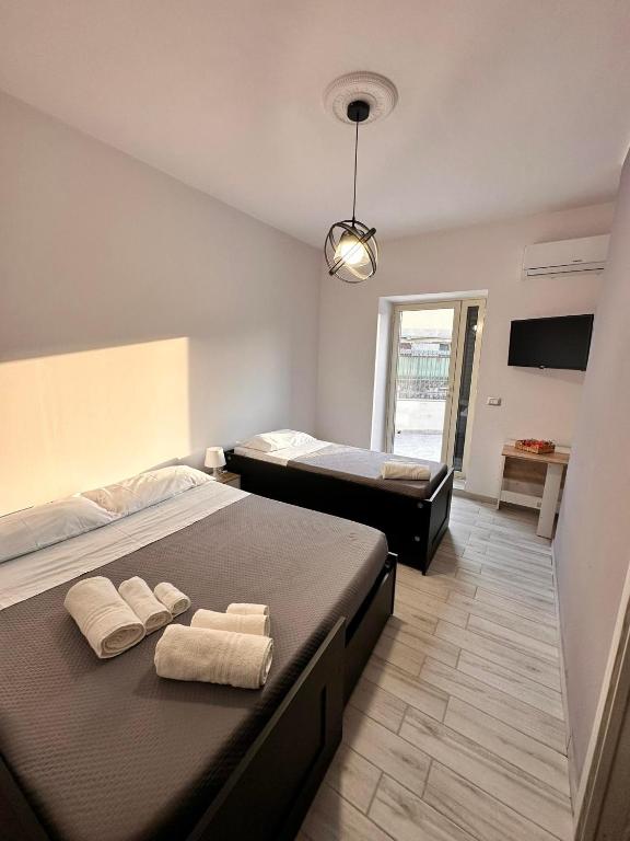 sypialnia z 2 łóżkami i ręcznikami w obiekcie Airport Al Volo B&B w Katanii